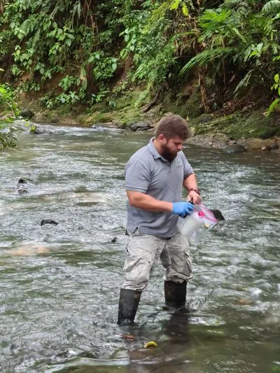 Técnico tomando una muestra de agua en campo